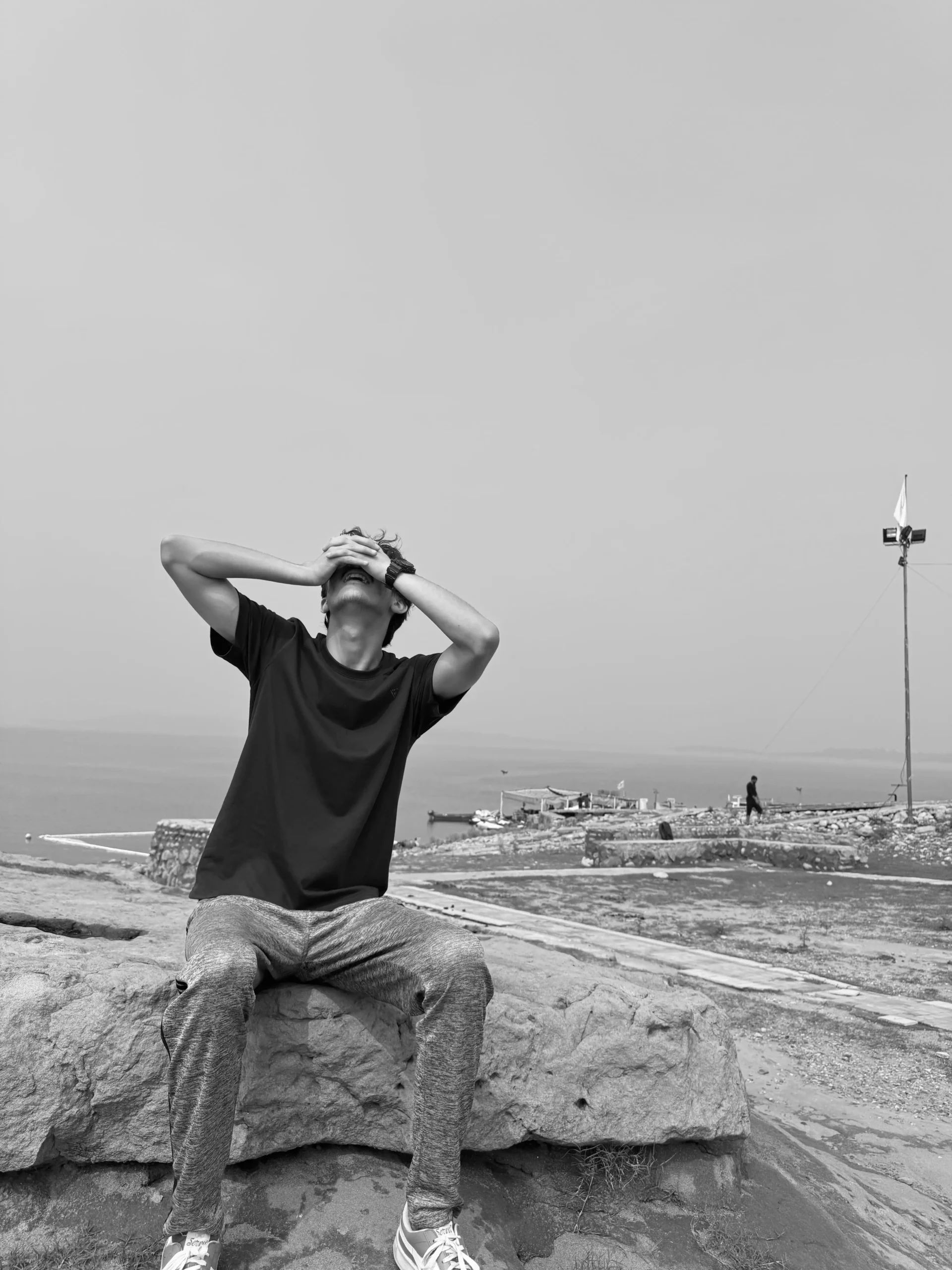 Munim Khan looking upward and covering face with hands