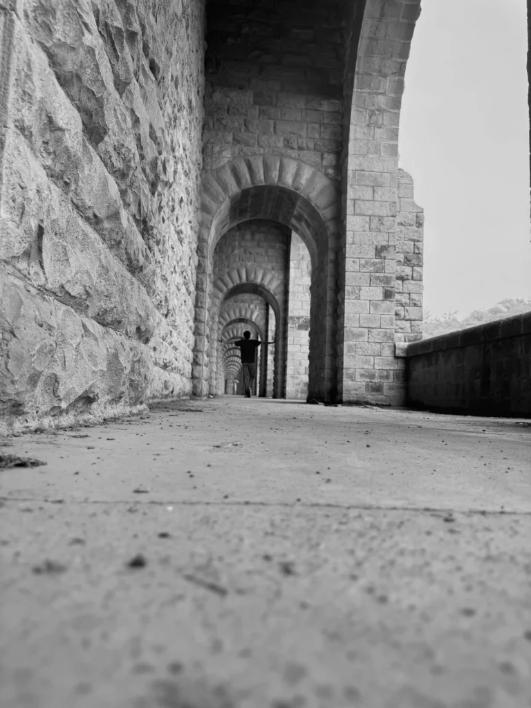 Munim khan standing at the end of a long open hallway
