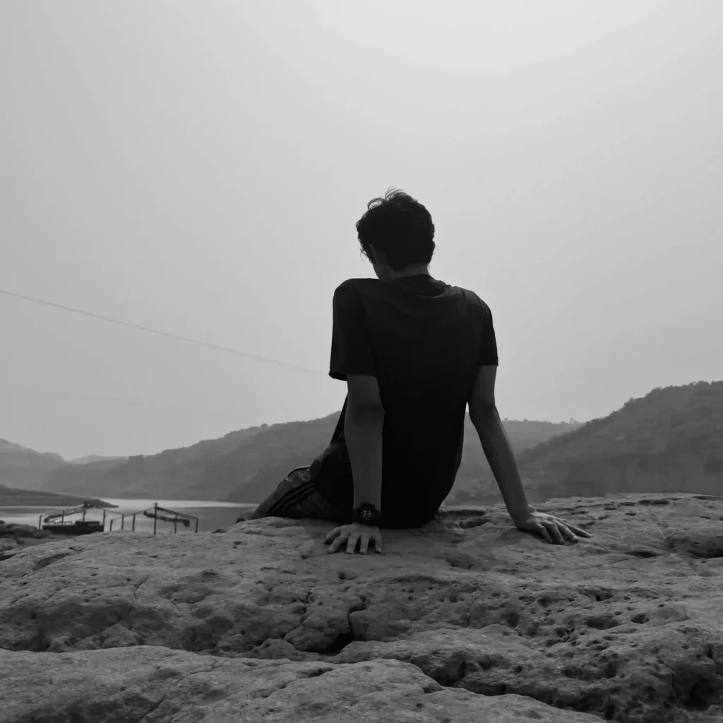 Munim Khan sitting on a rock overlooking the calm water at Mangla resort