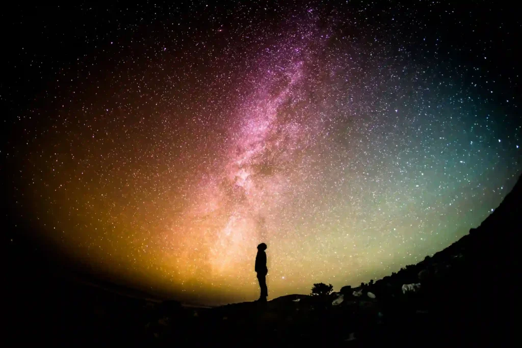 Figure beneath an open sky symbolizing human awareness, activation of consciousness, and perception beyond biological limits