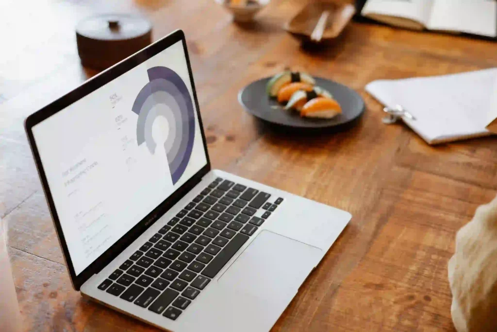 Laptop showing a service landing page with low conversion analytics and user drop-off graph
